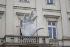 Huge hand out of a balcony Collegium Nobilium building The Aleksander 